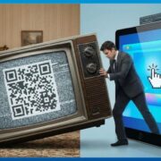 A person in a business suit struggles to push a vintage television set displaying a "DIGITAL" neon sign through a giant tablet screen displaying a modern analytics dashboard. This visual metaphor represents the friction of trying to force traditional TV advertising into a modern digital framework.